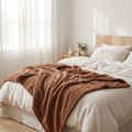 Cooling summer blanket draped on a linen bed